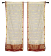 Cream sari rod pocket curtains hung at a window