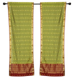 Green sari rod pocket curtains hung at a window