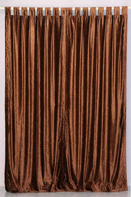 Brown velvet tab top curtains hung at a window