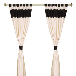 Cream raw silk tab top curtains hung at a window