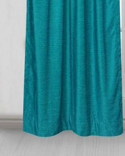 Turquoise velvet rod pocket curtains hung at a window