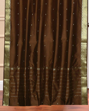 Brown sari grommet top curtains hung at a window