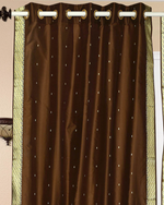 Brown sari grommet top curtains hung at a window