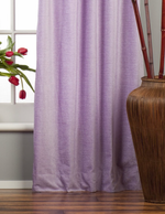 Lavender velvet grommet top curtains hung at a window