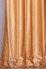 Peach velvet grommet top curtains hung at a window