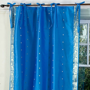 Blue sari tie top curtains hung at a window