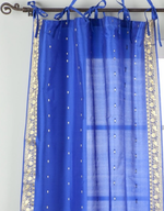 Blue sari tie top curtains hung at a window