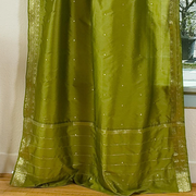 Olive green sari tie top curtains hung at a window