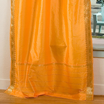 Pumpkin sari tie top curtains hung at a window