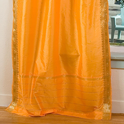 Pumpkin sari tie top curtains hung at a window
