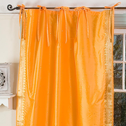 Pumpkin sari tie top curtains hung at a window