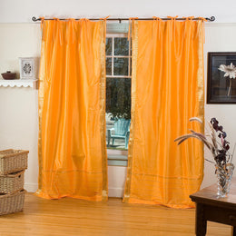 Pumpkin sari tie top curtains hung at a window