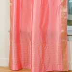 Pink sari tie top curtains hung at a window