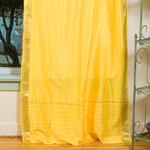 Yellow sari tie top curtains hung at a window
