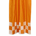 Orange sari tab top curtains hung at a window