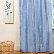 Light blue velvet tab top curtains hung at a window