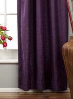 Purple velvet tab top curtains hung at a window