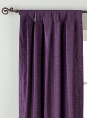 Purple velvet tab top curtains hung at a window