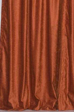 Rust velvet tab top curtains hung at a window