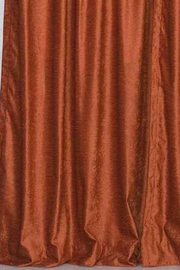 Rust velvet tab top curtains hung at a window