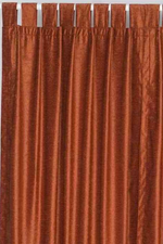 Rust velvet tab top curtains hung at a window