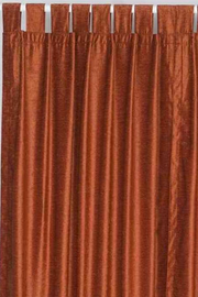 Rust velvet tab top curtains hung at a window