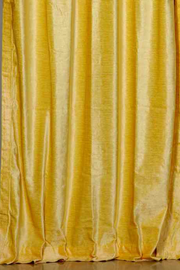 Yellow velvet tab top curtains hung at a window