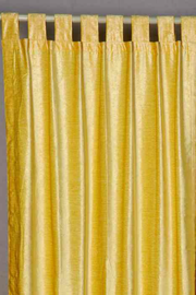 Yellow velvet tab top curtains hung at a window