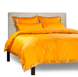 Pumpkin sari duvet cover set made up on a bed