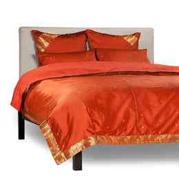 Rust sari duvet cover set made up on a bed