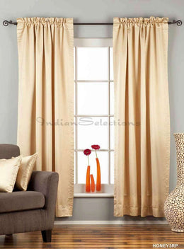 Golden rod sari rod pocket curtains hung at a window