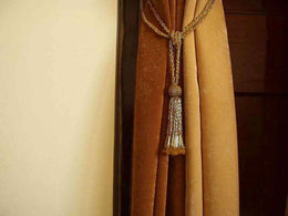 Golden sari curtain tiebacks holding a panel open