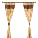 Brown raw silk tab top curtains hung at a window