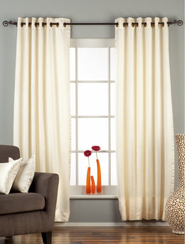 Cream sari grommet top curtains hung at a window