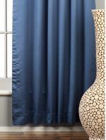 Blue sari grommet top curtains hung at a window