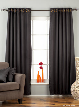 Black sari grommet top curtains hung at a window