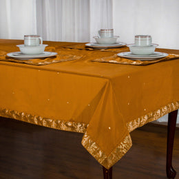 Earthy mustard sari tablecloth laid on a dining table