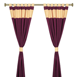 Maroon raw silk tab top curtains hung at a window