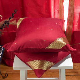 Maroon sari cushion covers arranged on a sofa