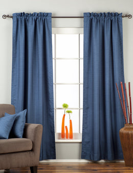 Blue raw silk rod pocket curtains hung at a window