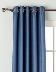 Blue raw silk ring top curtains hung at a window