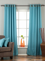 Turquoise raw silk ring top curtains hung at a window