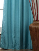 Turquoise raw silk ring top curtains hung at a window