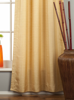 Golden raw silk tab top curtains hung at a window