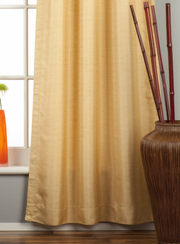 Golden raw silk tab top curtains hung at a window