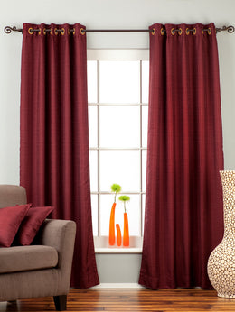 Maroon raw silk ring top curtains hung at a window