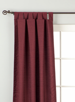 Maroon raw silk tab top curtains hung at a window