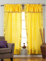 Cream sari rod pocket curtains hung at a window