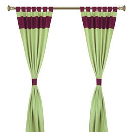 Olive green raw silk tab top curtains hung at a window