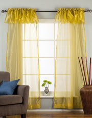 Gold sheer tissue rod pocket curtains hung at a window